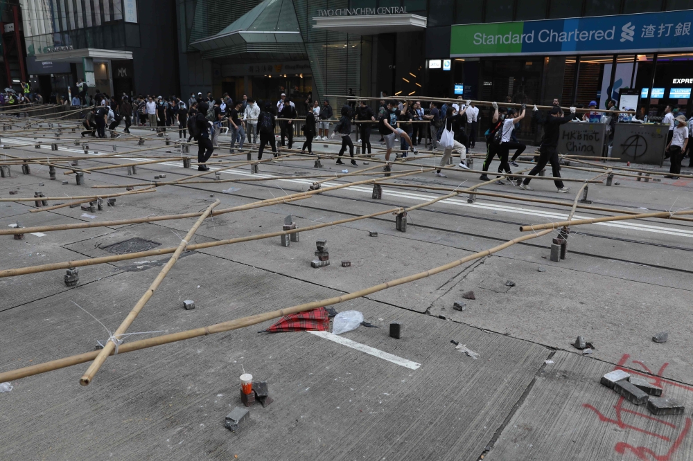 Protesters and office workers set up a barricade of bamboo and bricks during a protest in the Central district in Hong Kong on November 13, 2019. AFP / Dale DE LA REY