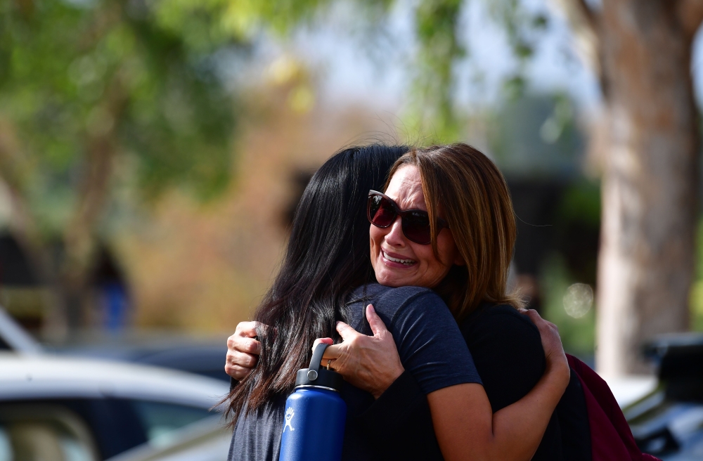 Women embrace in Central Park after a shooting at Saugus High School in Santa Clarita, California on November 14, 2019. / AFP / Frederic J. BROWN 