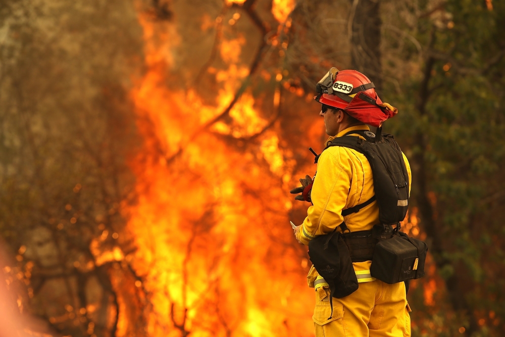 A firefighter looks on as the Carr Fire moves through the area on July 28, 2018 in Redding, California. Justin Sullivan / Getty Images / AFP