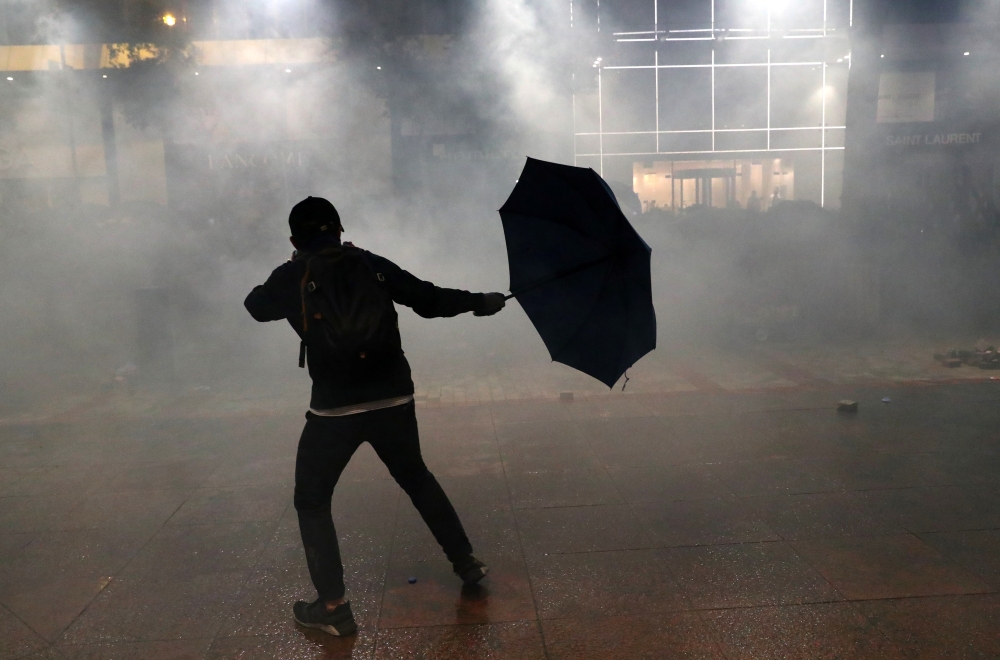 An anti-government demonstrator reacts amid tear gas during protests at Tsim Sha Tsui, in Hong Kong, China, November 18, 2019. Reuters/Athit Perawongmetha
 
