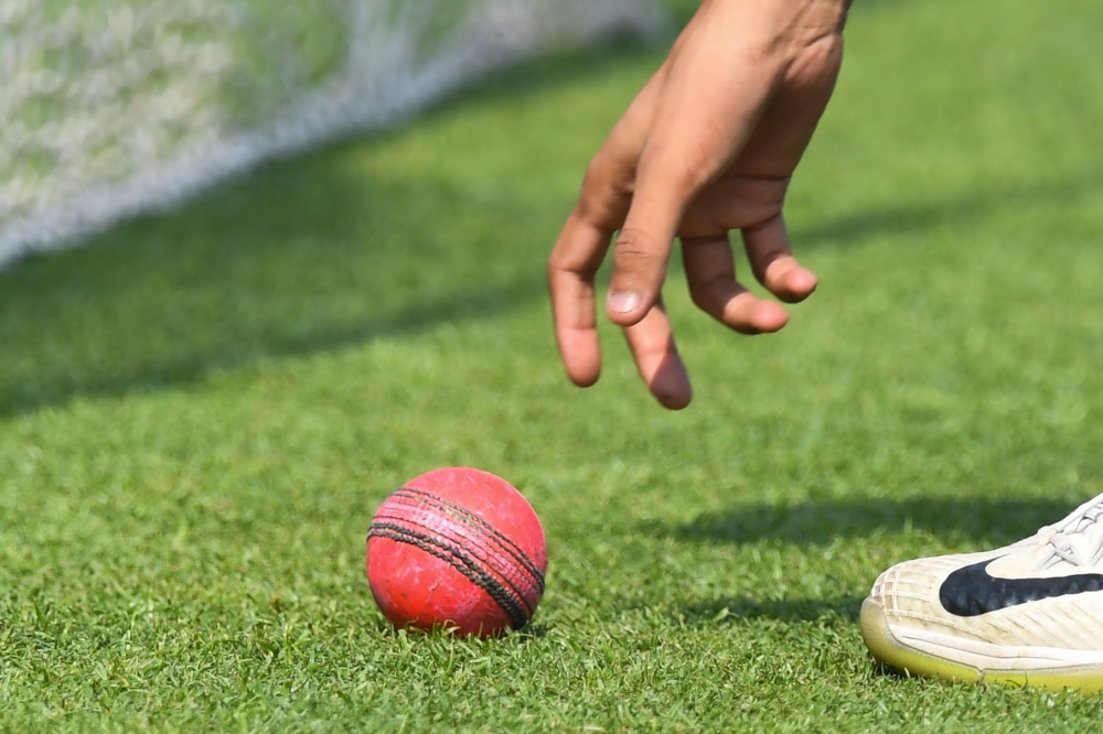 A cricketer picks up a pink ball during Bangladesh's practice session at The Eden Gardens cricket stadium in Kolkata on November 20, 2019, ahead of the second Test cricket match between India and Bangladesh. / AFP / Dibyangshu SARKAR 