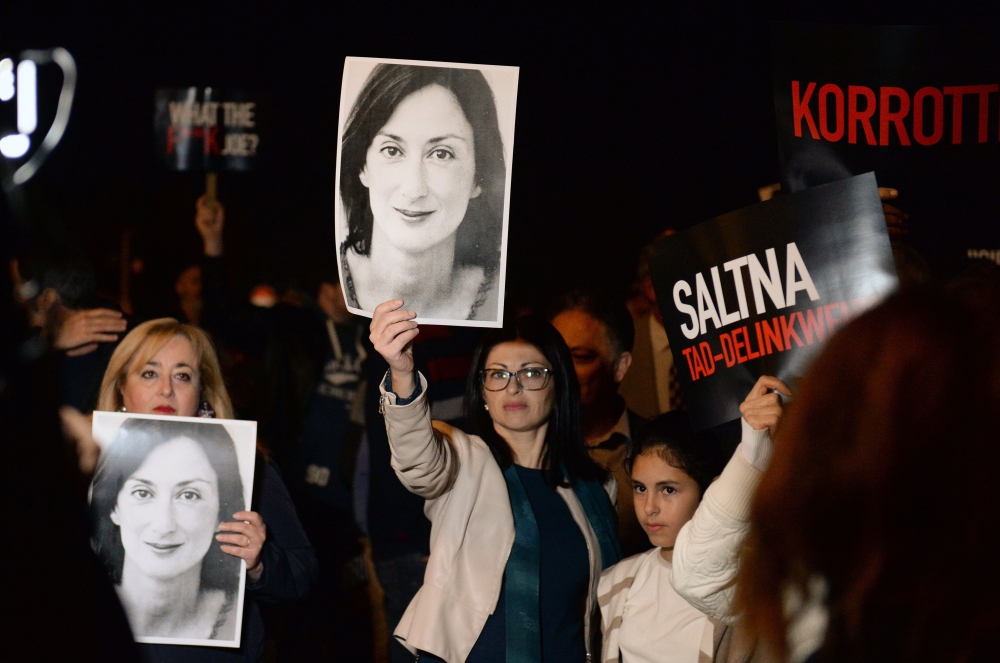 Protesters hold up placards and pictures of the late journalist Daphne Caruana Galizia as they gather outside the prime minister's office in Valletta, Malta on November 20, 2019.  AFP / Matthew Mirabelli 