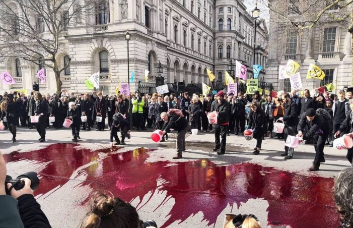 Members of the Extinction Rebellion pour artificial blood during a climate protest outside 10 Downing Street in London, March 9, 2019. Credit:  Extinction Rebellion