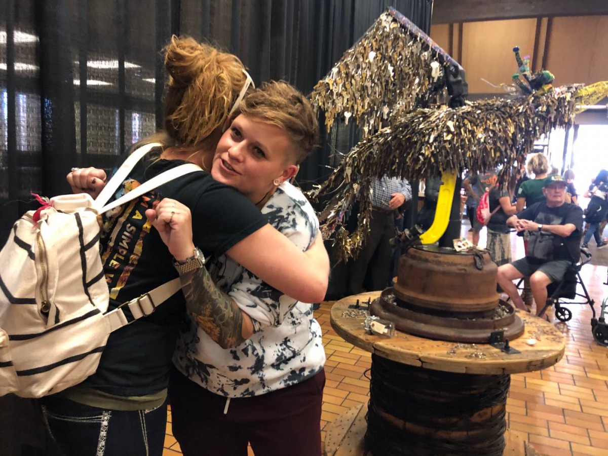Artist Jessie Mercer gives a resident of wildfire-hit Paradise, California, a hug near her sculpture Key Phoenix, made with keys from thousands of homes and buildings lost in the November 2018 blaze, Nov. 8, 2019. Thomson Reuters Foundation/Ellen Wulfhors
