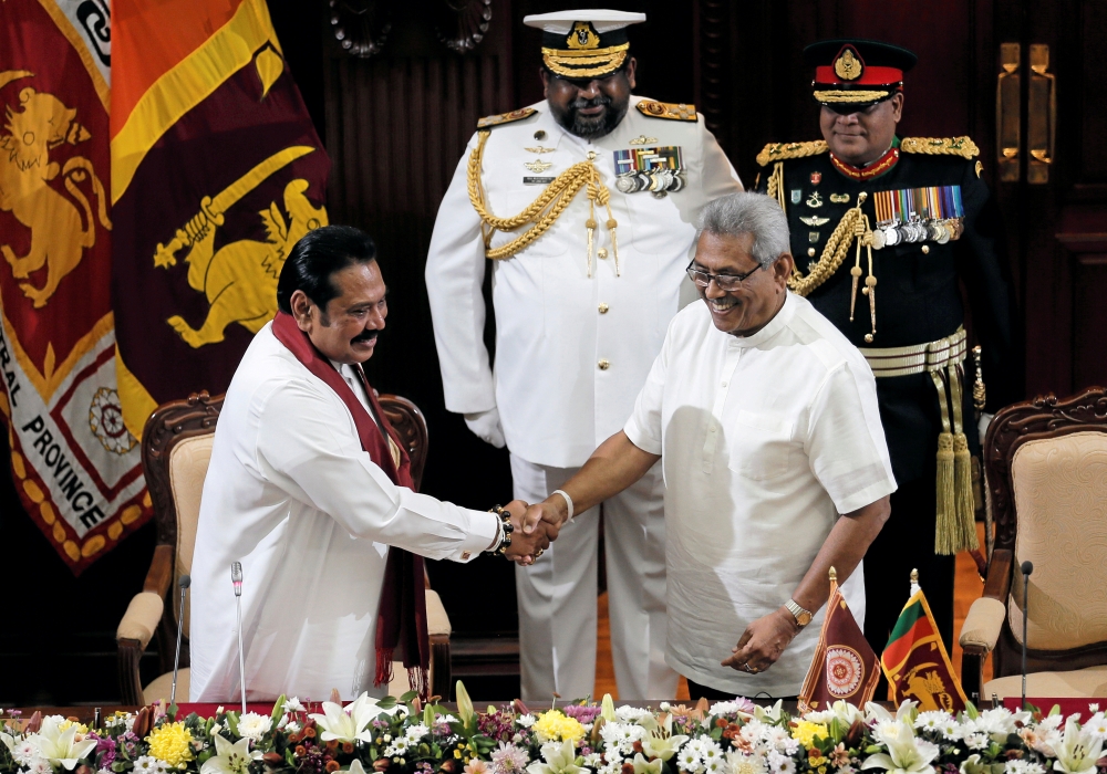 Sri Lanka's President Gotabaya Rajapaksa and his brother and former leader Mahinda Rajapaksa, who was appointed as the new Prime Minister, shake hands during the swearing in ceremony in Colombo, Sri Lanka November 21, 2019. REUTERS/Dinuka Liyanawatte