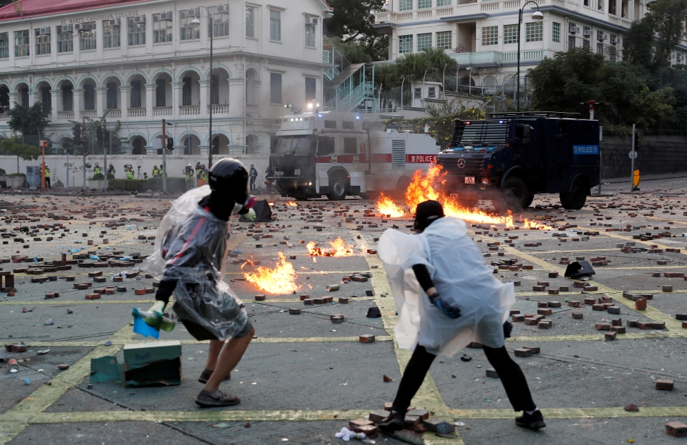 Anti-government protesters throw molotov cocktails towards police vehicles during clashes, outside Hong Kong Polytechnic University in Hong Kong, November 17, 2019. Reuters/Tyrone Siu