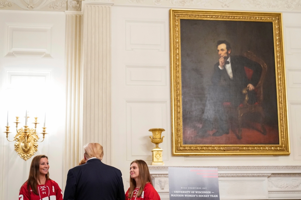 President Donald Trump speaks with members of the University of Wisconsin Madison women's hockey team during an 
