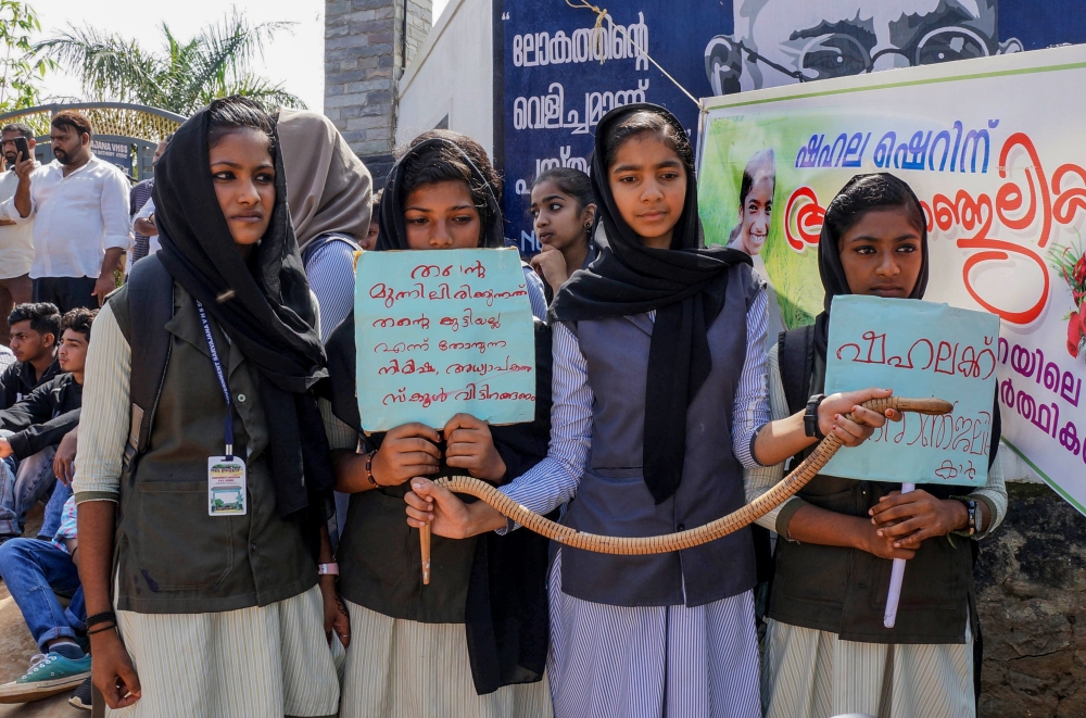 Students hold placards and a toy snake during a protest over the death of a girl after she was bitten by a snake inside her classroom at Sulthan Bathery in Wayanad's district in Kerala, India on November 22, 2019. AFP