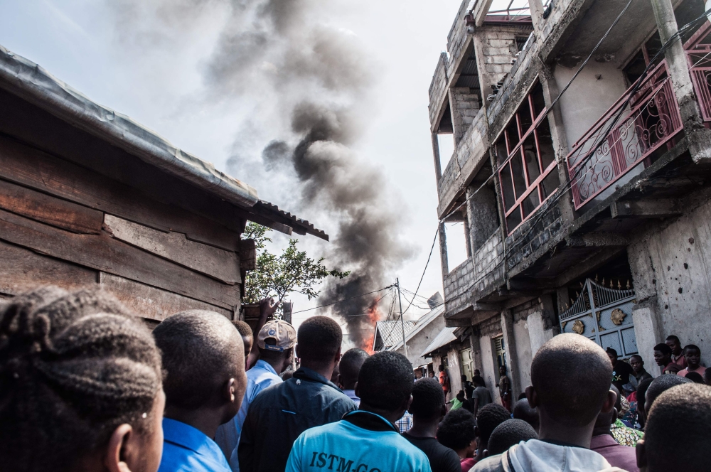 Residents react after a small aircraft carrying around 15 passengers crashed in a densely populated area in Goma on the East of the Democratic Republic of Congo on November 24, 2019. AFP / Pamela Tulizo 