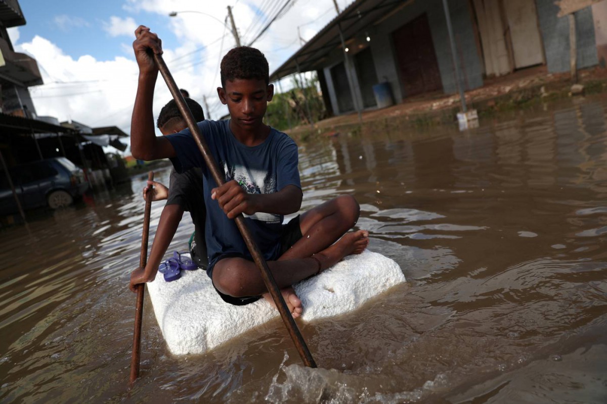 Kids row on a styrofoam block through a flooded street during heavy rains in the Guaratiba neighborhood in Rio de Janeiro, Brazil April 10, 2019. Reuters/Ricardo Moraes