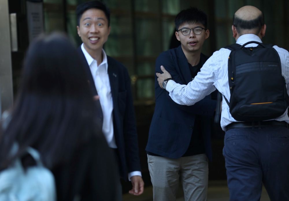 Winning candidate Kelvin Lam and activist Joshua Wong greet people and thank them for their support, outside South Horizons Station, in Hong Kong, China, November 25, 2019, the morning after Lam won in district council elections. REUTERS/Leah Millis