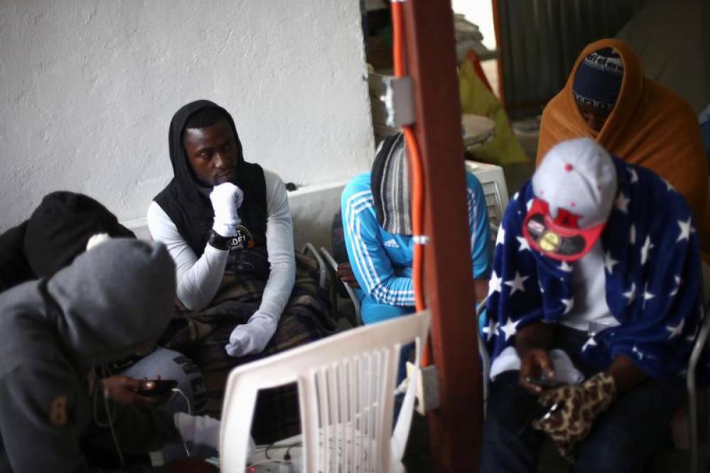 Migrants from Cameroon gather as they protect themselves from the cold inside the Juventud 2000 shelter in Tijuana, Mexico March 14, 2018. Reuters/Edgard Garrido