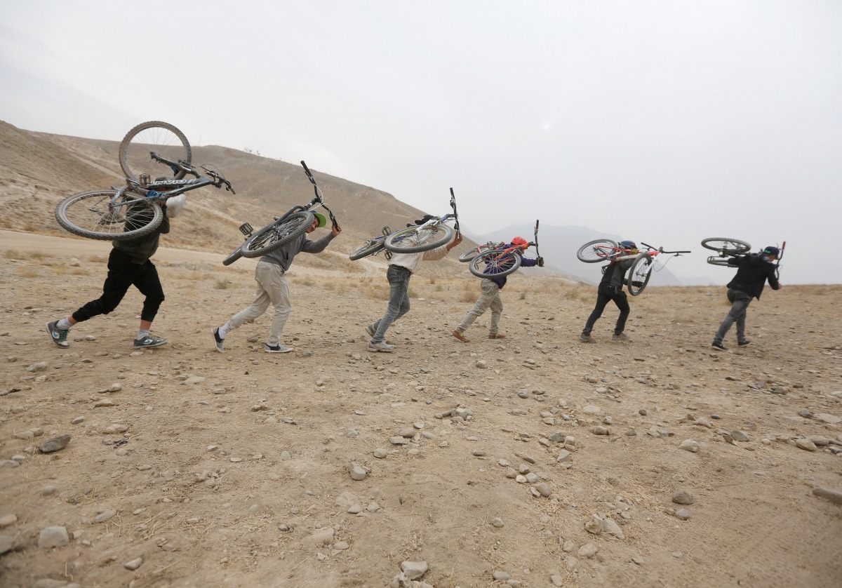 Young Afghan cyclists carry their bicycles on their back on a hill during an exercise on the outskirts of Kabul, Afghanistan, November 20, 2016. Reuters / Omar Sobhani