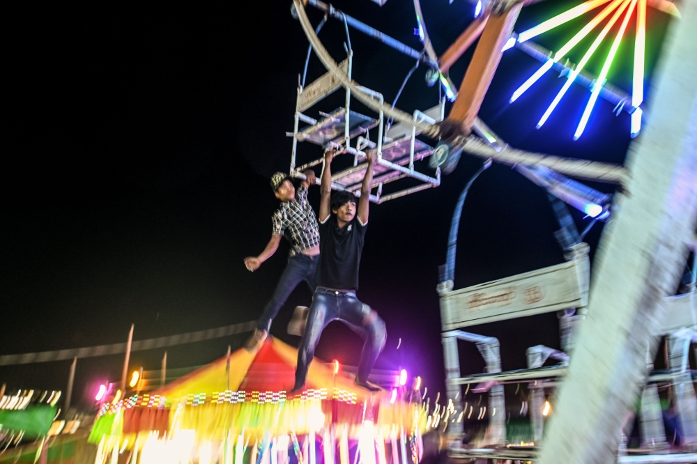 This photo taken on November 6, 2019 shows crew members operating a human-powered ferris wheel in Taunggyi, Shan state. AFP / Ye Aung Thu
 