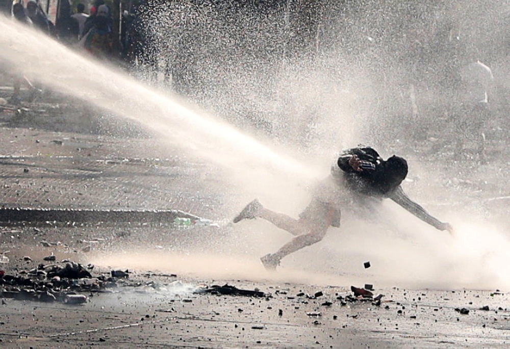 A demonstrator is sprayed by a water cannon during a protest against Chile's government in Santiago, Chile, November 26, 2019. REUTERS/Ivan Alvarado
