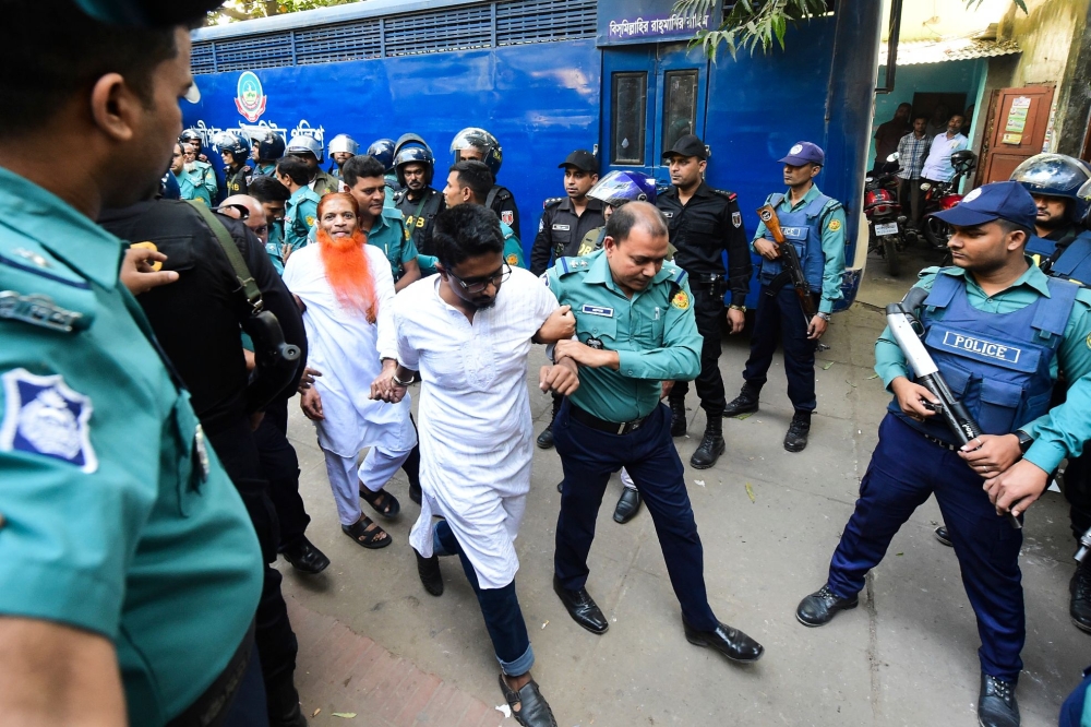 Police escort detainees (C) accused of allegedly plotting the Holey Artisan Bakery cafe attack, carried out by Islamist militants, to a courtroom for their trial in Dhaka on November 27, 2019. AFP / Munir UZ ZAMAN