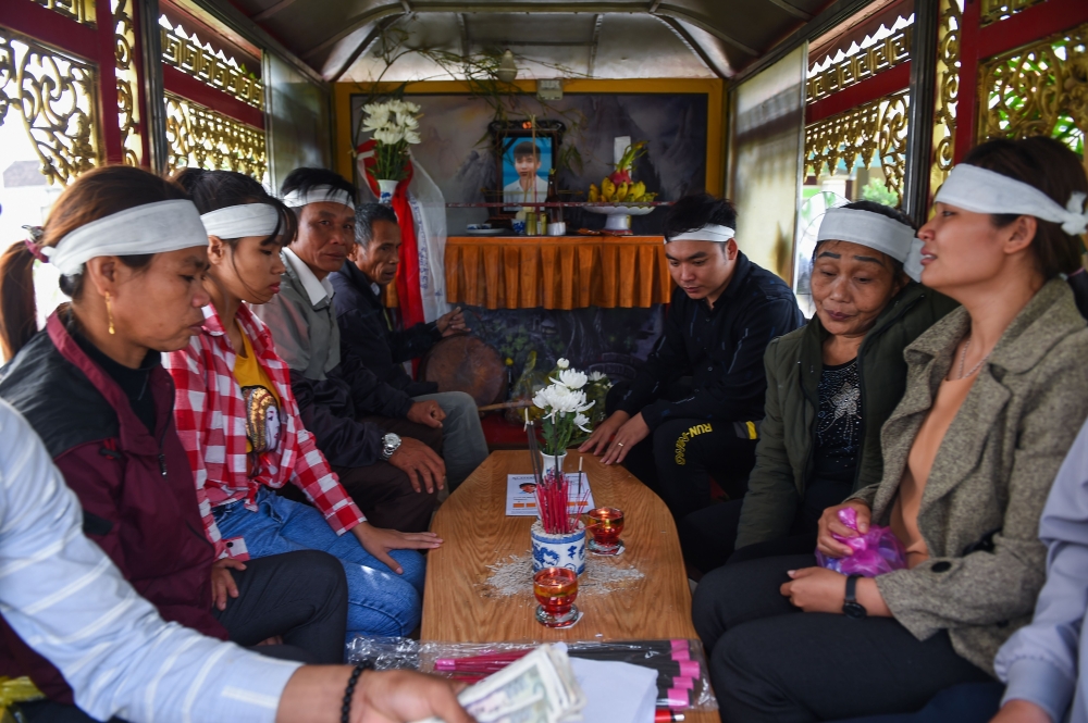 The family of Vo Van Linh transport his coffin bearing his remains on a funeral van for cremation in Can Loc district, Ha Tinh province on November 28, 2019. The first remains of the 39 people found dead in a truck in Britain last month arrived in Vietnam