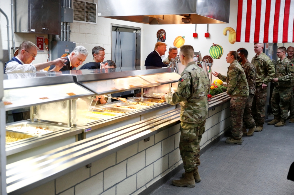 US President Donald Trump serves U.S. troops food at a Thanksgiving dinner event during a surprise visit at Bagram Air Base in Afghanistan, November 28, 2019. Reuters/Tom Brenner
 