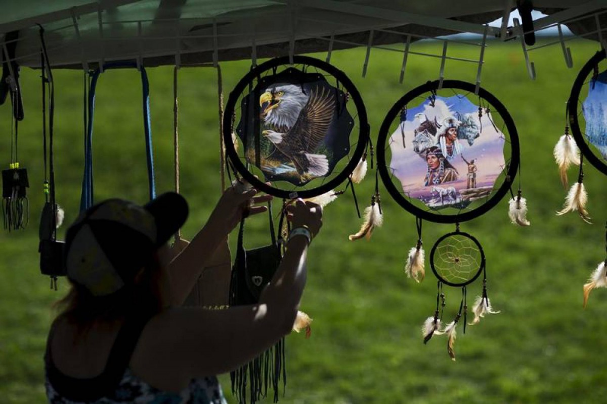 A woman organizes indigenous items after a Sunrise Ceremony during a 