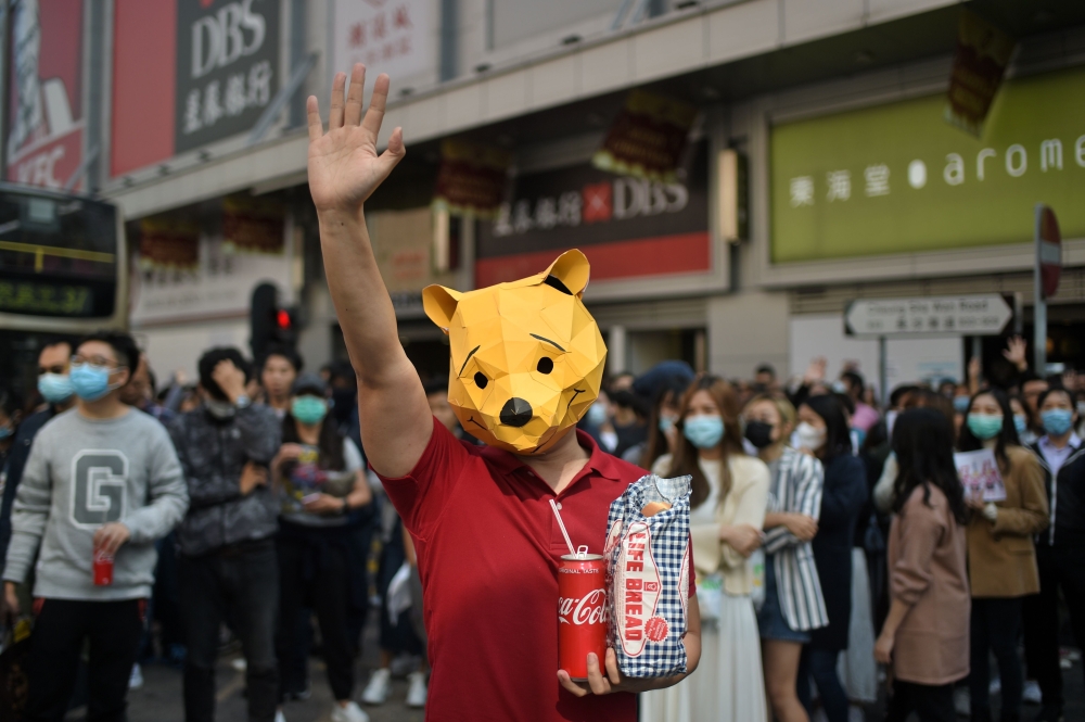 A man wears a “Winnie the Pooh“ mask as he joins others in a lunchtime flash mob rally in the Cheung Sha Wan district in Hong Kong on November 29, 2019. AFP / Philip Fong
 