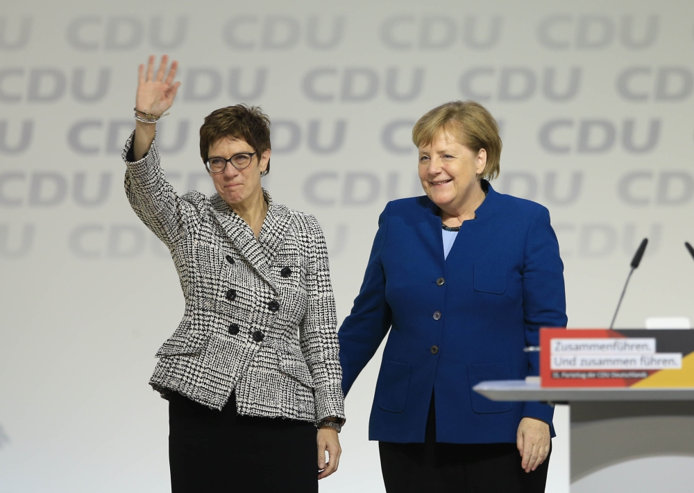 Annegret Kramp-Karrenbauer greets delegates while she stands next to Angela Merkel after she has been elected as new CDU party leader in Hamburg Germany on December 7, 2018. (Abdülhamid Ho?ba? / Anadolu Agency) 