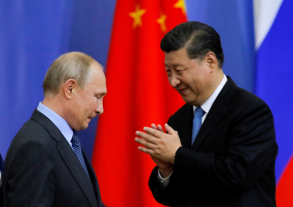 FILE PHOTO: Chinese President Xi Jinping and Russian President Vladimir Putin attend the ceremony of presenting Xi Jinping with a degree from the St Petersburg State University at the St Petersburg International Economic Forum in St. Petersburg, Russia, J
