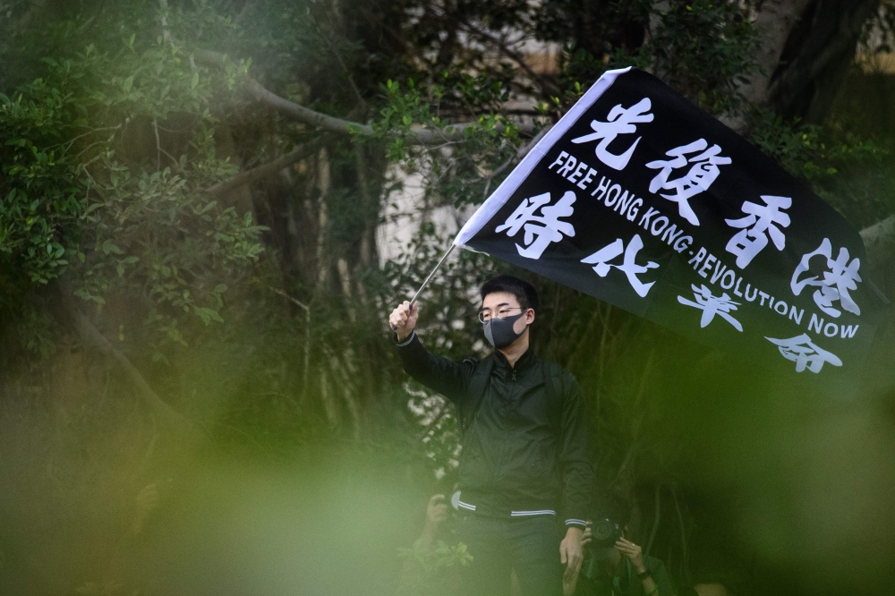 A man waves a flag that reads 