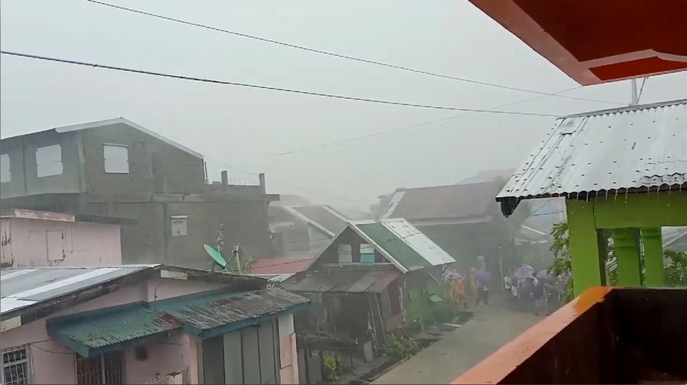 People walk as Typhoon Kammuri, known locally as Typhoon Tisoy, makes landfall in Gamay, Northern Samar, Philippines, December 2, 2019, in this still image from video obtained via social media. Gladys Castillo Vidal via Reuters