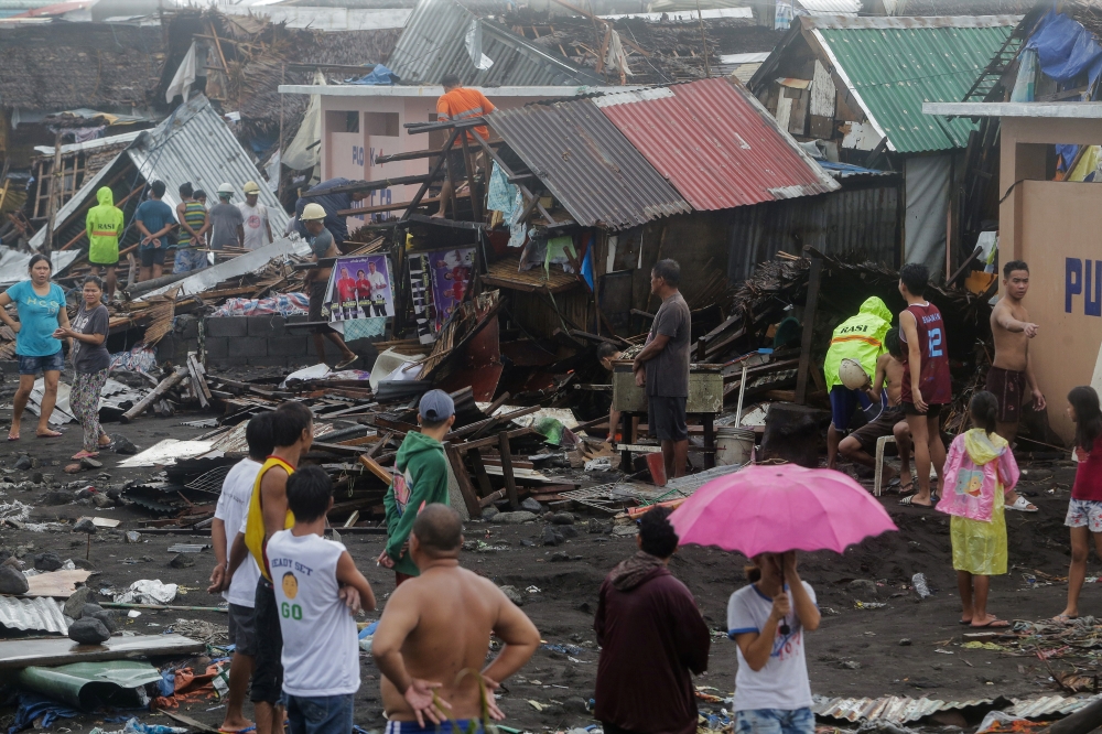 Residents stand among their damaged houses after Typhoon Kammuri hit Legazpi City, Albay, Philippines, December 2, 2019. REUTERS/Nino Luces