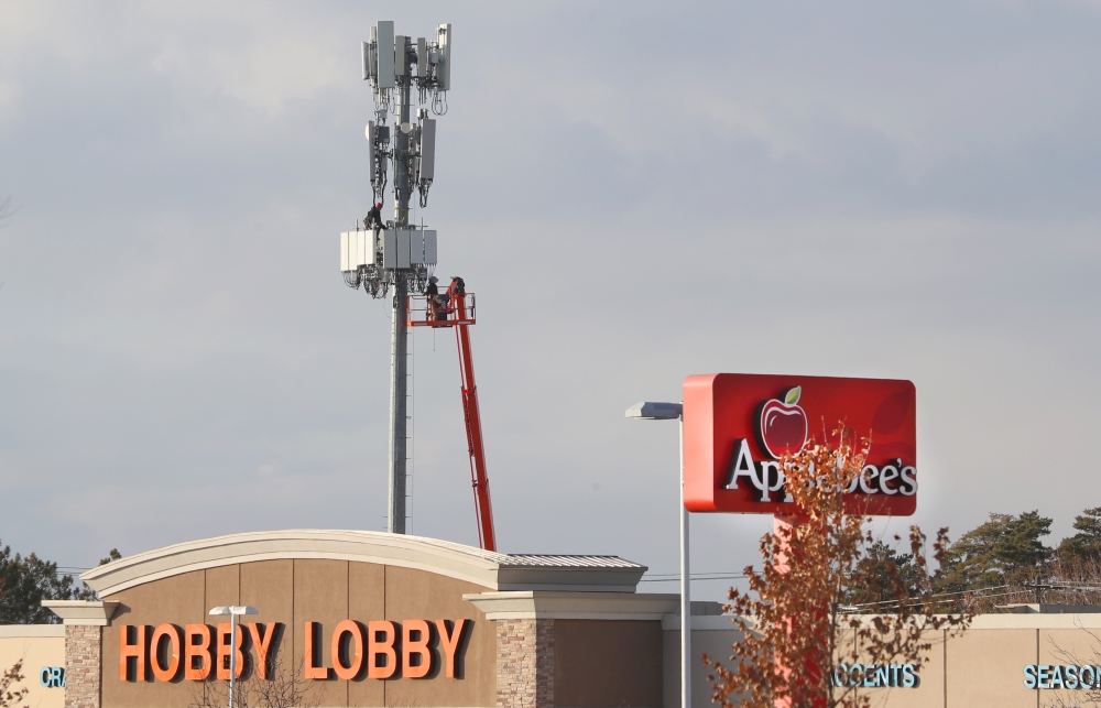 Several stores sits in front of a cell tower as Workers rebuild a cellular tower with 5G equipment for the Verizon network on November 26, 2019 in Orem, Utah. George Frey/Getty Images/AFP