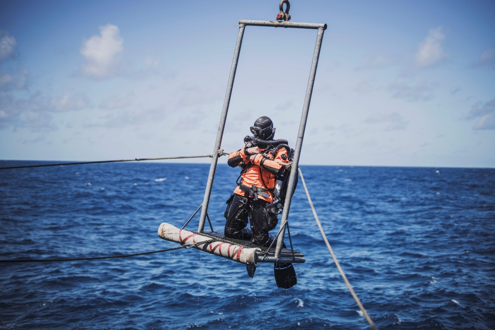 A diver is taken onboard the Greenpeace vessel Arctic Sunrise at the end of an exploration of Vema Sea Mount, on October 31, 2019.  AFP / Marco Longari
 