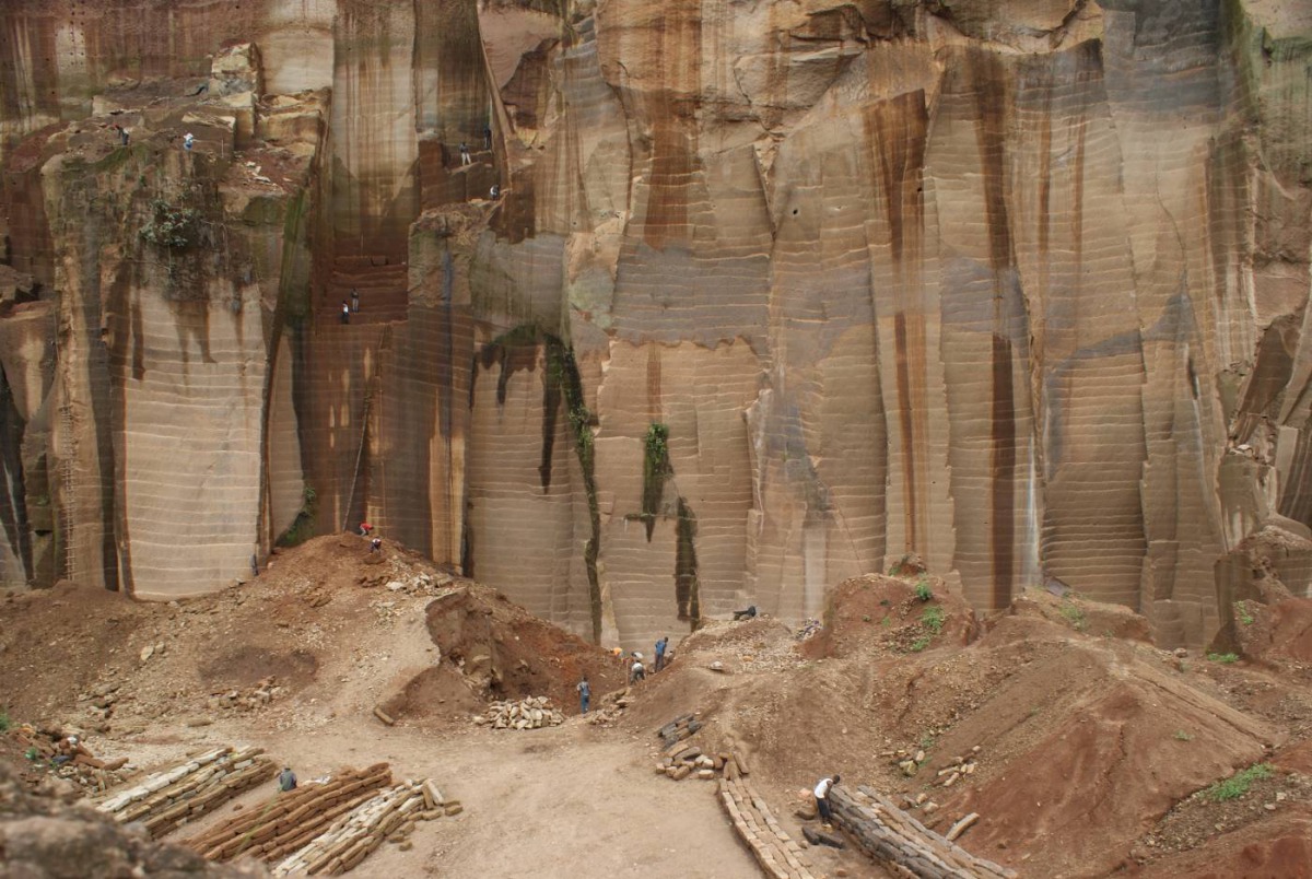 Workers mine rocks as trucks wait to transport it to various construction sites in Mutonga quarry, Meru county, Kenya. Photo taken on 2 December 2019. Thomson Reuters Foundation/Kagondu Njagi