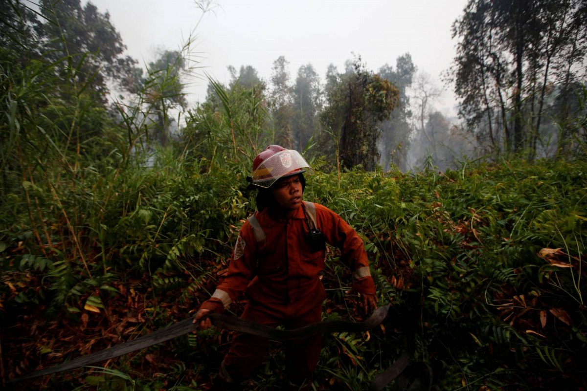 Bimpi Permata Restu, 18, who is a volunteer at Greenpeace's Forest Fire Prevention, holds a hose as he prepares to extinguish forest fires in Pulang Pisau regency near Palangka Raya, Central Kalimantan province, Indonesia, September 13, 2019. Reuters/Will