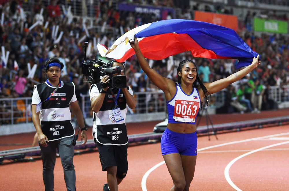 Kristina Marie Knott from the Philippines celebrates after winning in the women's 200m athletics event at the SEA Games (Southeast Asian Games) at the athletics stadium in Clark, Capas, Tarlac province north of Manila on December 7, 2019. / AFP / TED ALJI
