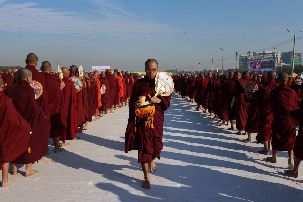Monks line up for alms during the alms-giving ceremony to 30,000 monks organize by the region government of Mandalay affiliated with Dhammakaya Foundation at Chanmyathazi Airport in Mandalay on December 8, 2019.  / AFP / KYAW ZAY WIN
 