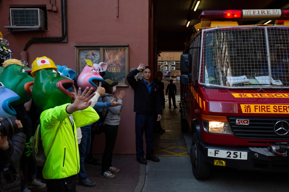 People wearing masks depicting Pepe the Frog, a character used by pro-democracy activists as a symbol of their struggle, make way for a fire truck to exit before the 'Human Rights Day' rally from Victoria Park to Chater Road in Hong Kong on December 8, 20