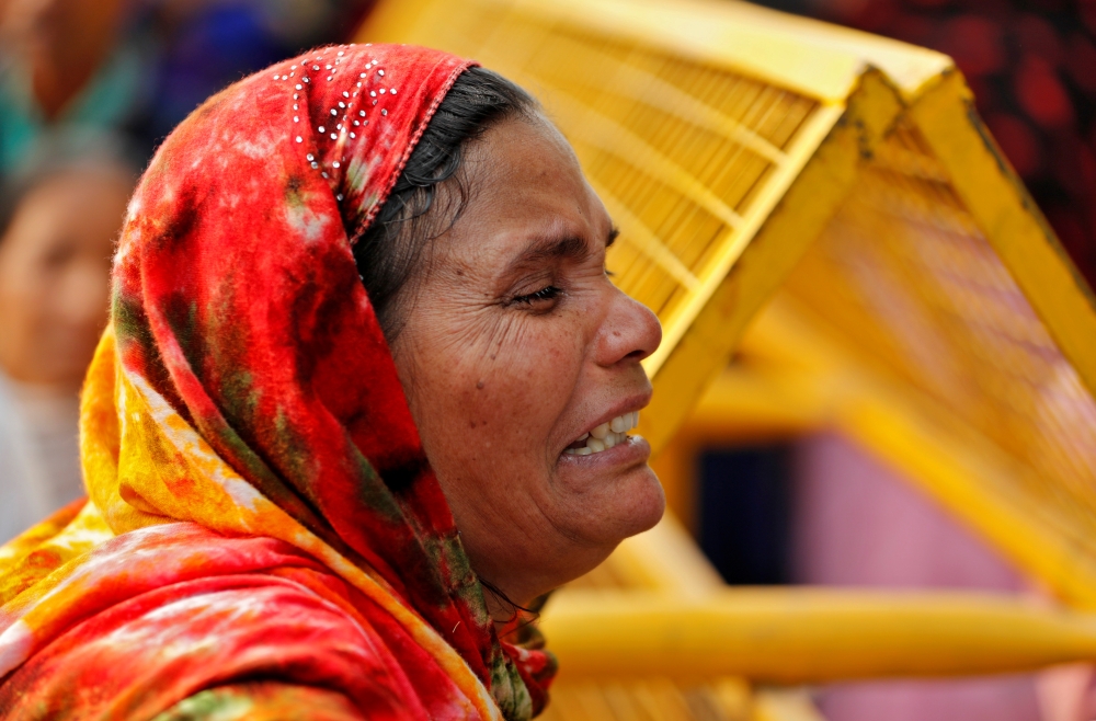 A relative of a victim of a fire that swept through a factory where laborers were sleeping, cries outside a hospital mortuary in New Delhi, India December 8, 2019. Reuters/Adnan Abidi