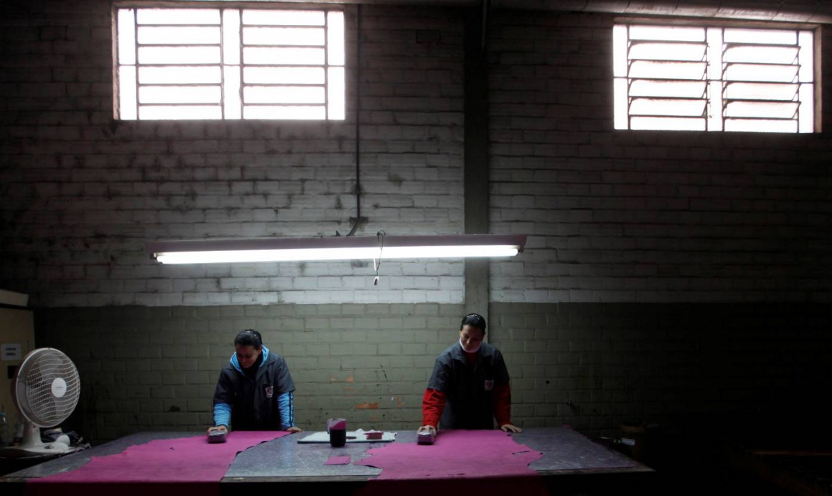 Brazilian workers give a colour on a piece of leather which will be used as leather to make shoes during a shoe-making process at a factory in Novo Hamburgo in the state of Rio Grande do Sul August 5, 2010.