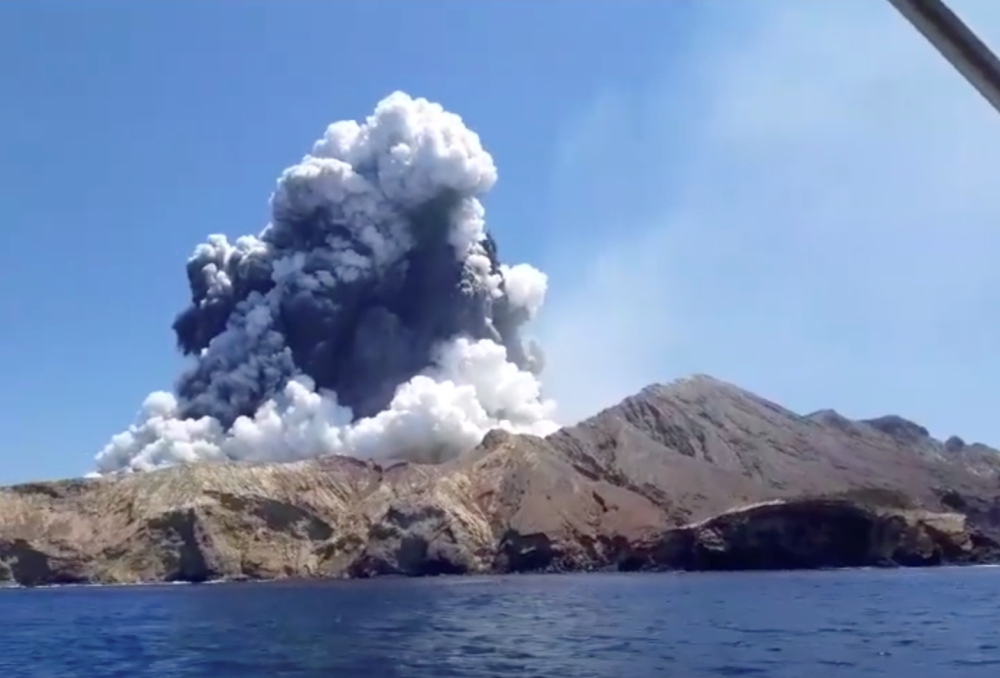 Smoke from the volcanic eruption of Whakaari, also known as White Island, is pictured from a boat, New Zealand December 9, 2019 in this picture grab obtained from a social media video - via REUTERS