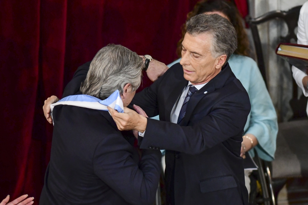 Argentina's incoming president Alberto Fernandez (L) receives the presidential sash from outgoing president Mauricio Macri .December 10, 2019. / AFP / Ronaldo SCHEMIDT

