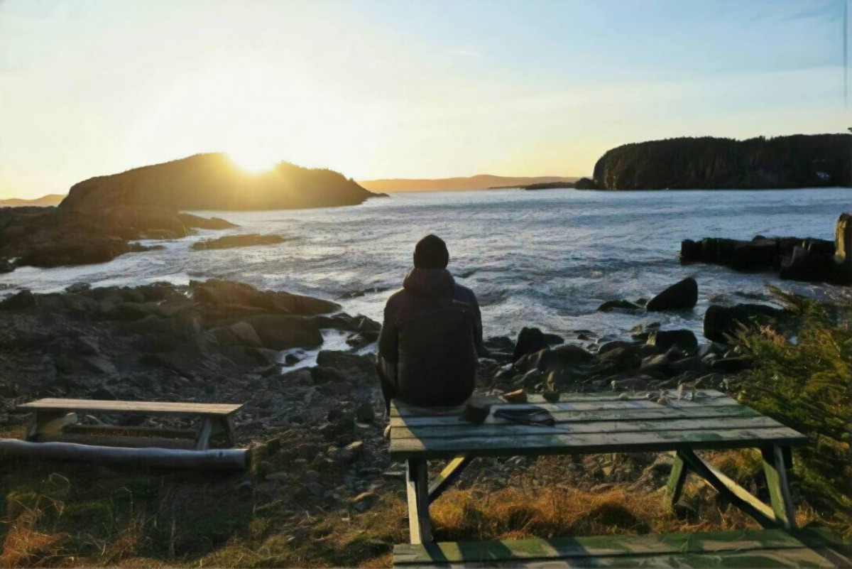 Michael Parsons watches the sunrise from Back Beach, Little Bay Islands, Canada, November 2, 2019. Photo handout by Michael Parsons