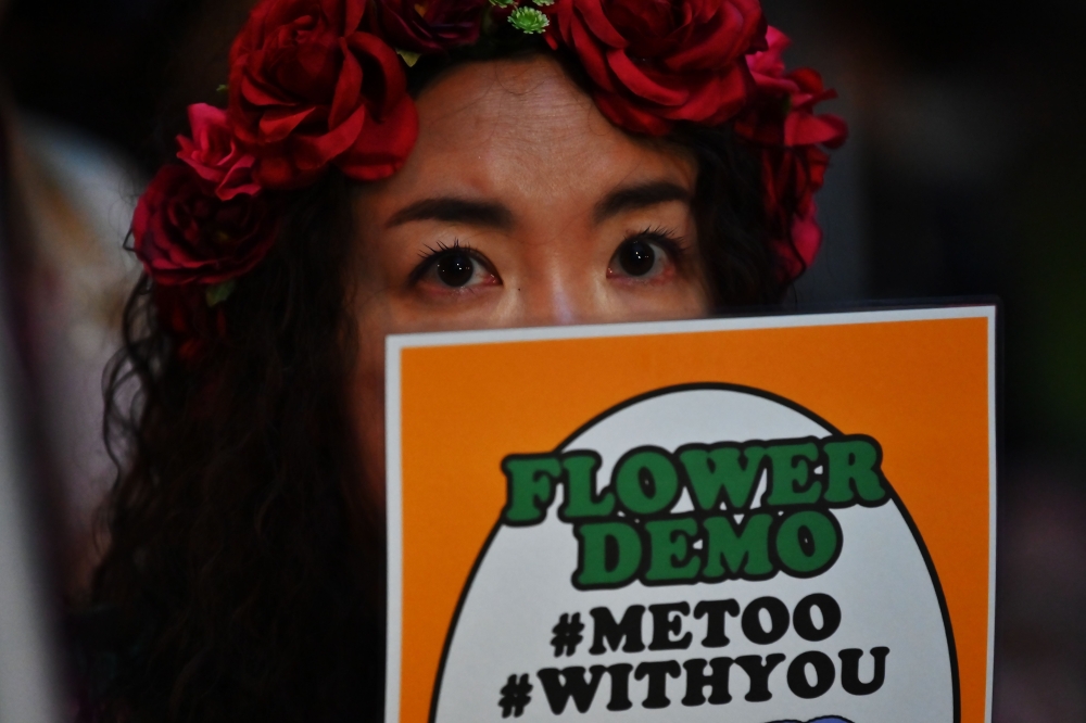 This file photo taken on June 11, 2019 shows a demonstrator holding a placard during a protest against the lack of substantial legal protection for sexual assault victims in Tokyo. AFP / Charly Triballeau
