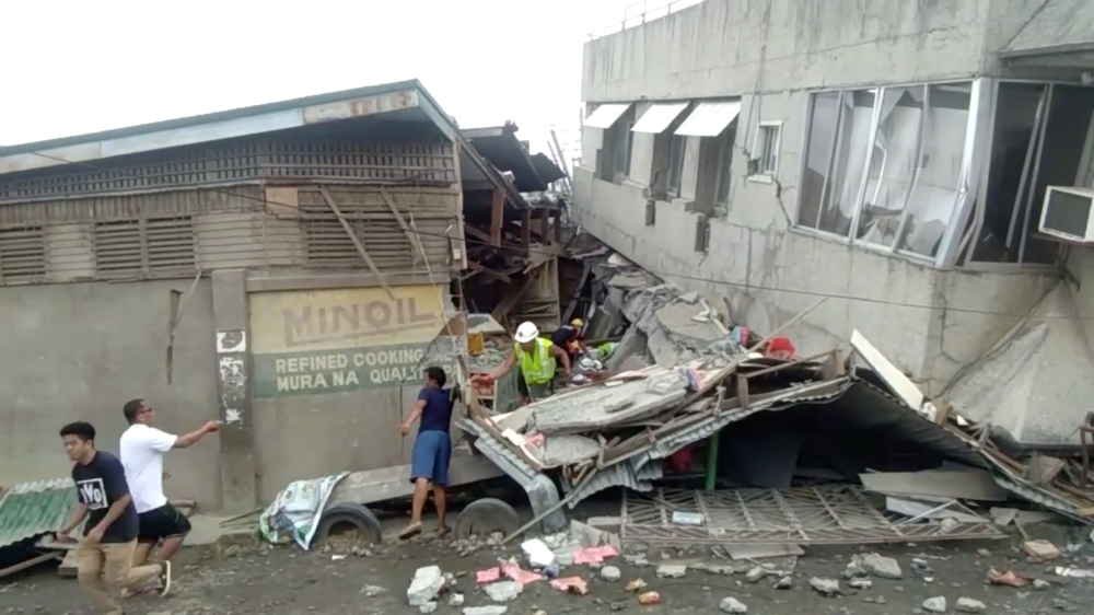 Rescue crew members look for trapped victims at collapsed building at Padada market, in Padada Philippines December 15, 2019 in this still image obtained from social media video. VINCENT YAJ MAKIPUTIN/via REUTERS 