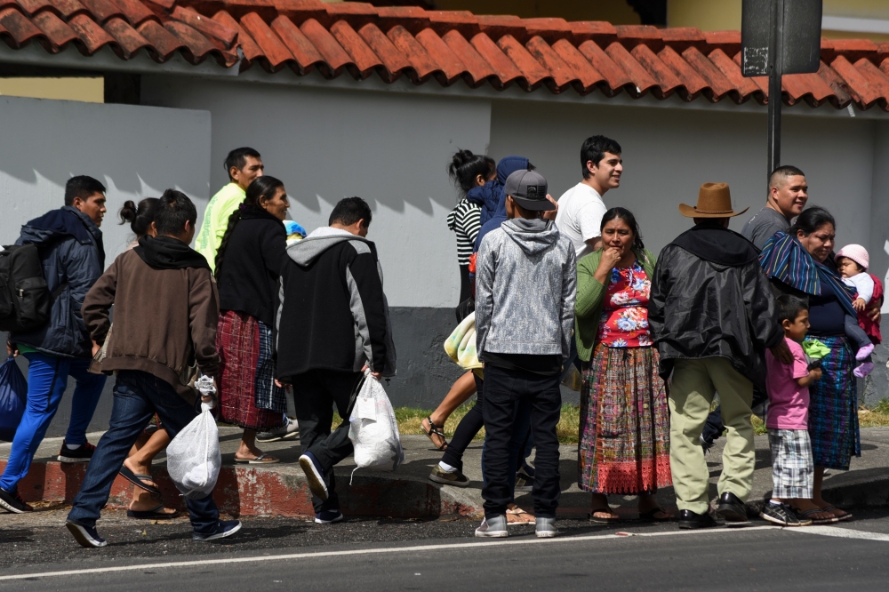 Migrants deported from the United States are seen outside the air force base upon their arrival in Guatemala City on December 12, 2019. AFP / Orlando Estrada 