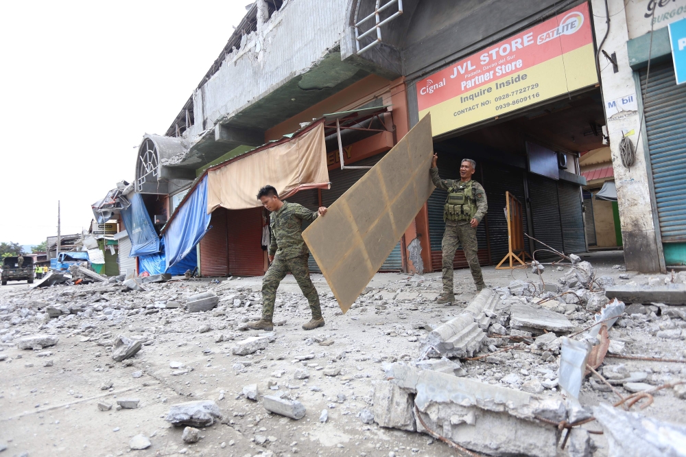Soldiers walk among debris in Padada town, Davao del Sur province on the southern island of Mindanao on December 16, 2019, following a 6.8-magnitude earthquake on December 15. AFP / Manman Dejeto