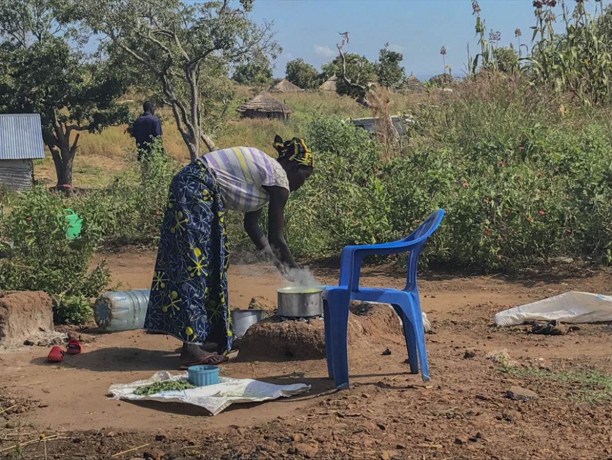 Emily Bronte's wife cooks over a fire at the family's home in the Bidi Bidi refugee settlement. Yumbe district, Uganda. Picture taken Nov. 29, 2019. Thomson Reuters Foundation/Claire Cozens