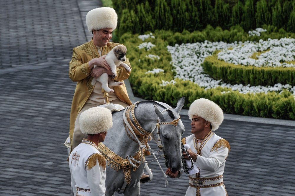 Turkmenistan's President Gurbanguly Berdymukhamedov holds a Turkmen shepherd dog - locally known as Alabai - while mounted on a horse as he takes part in celebrations for the Day of the Horse in Ashgabat in this file photograph taken on April 28, 2018. AF