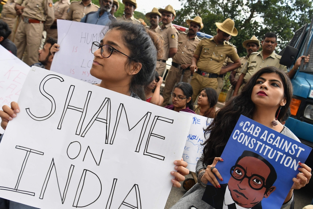 Students and activists hold placards and shout slogans during a protest againstCitizenship Amendment Bill in in Bangalore, India on December 16, 2019. AFP / Manjunath Kiran
 