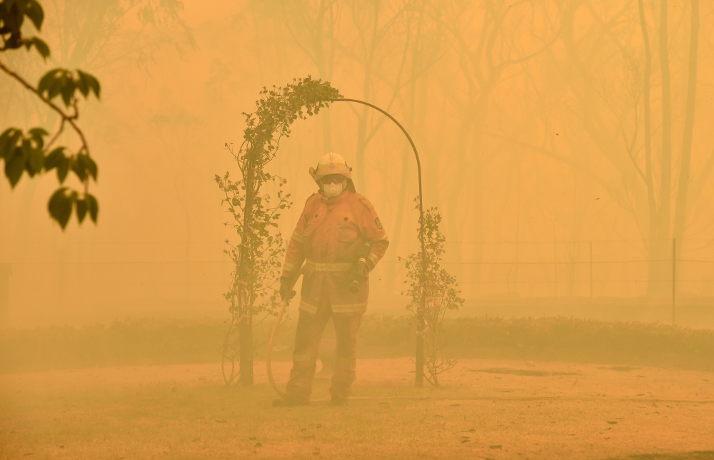 A fireman fights a bushfire to protect a property in Balmoral, 150 kilometres southwest of Sydney on December 19, 2019. (AFP / PETER PARKS)