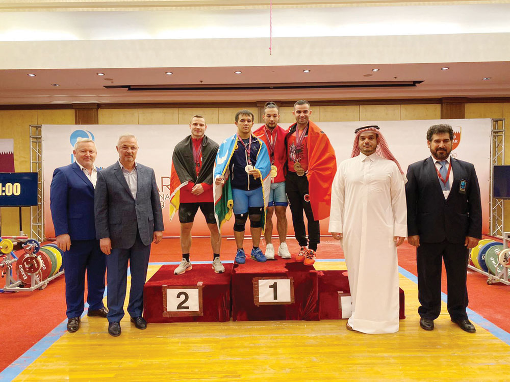 The podium winners of the men’s 73 weight class posing for a photograph with the officials.